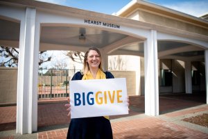 Woman with sign in front of museum entrance